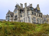 20170925 0477  Puxley Manor in Dunboy County Cork straalde eens de rijkdom uit van de Puxleys die in de buurt kopermijnen bezaten. Na het uitputten van het koper en bij het overlijden van zijn vrouw in het kraambed verliet de laatste Puxley de manor en het werd achteraf in brand gestoken door de IRA in 1921. Het werd in 1999 opgekocht door een investeringsmaatschappij en gerestaureerd tot een zes sterren hotel. Maar nog voor de opening in 2007 werd het project ondermijnd door de beurscrash en is sindsdien onbewoond en afgesloten door hekkens. In het belendend park staan nog een aantal exotische bomen. : Ierland 2017